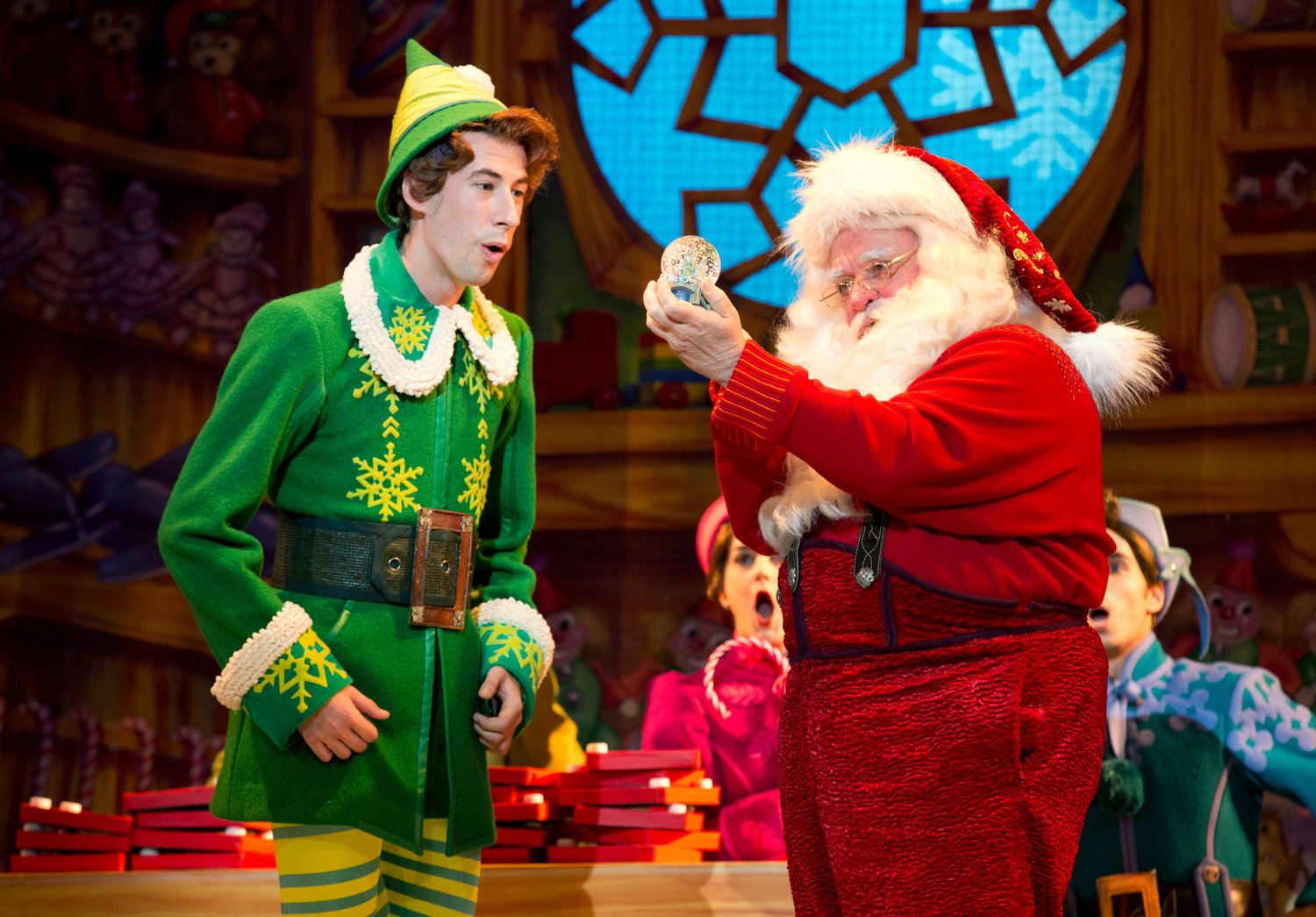 Santa (Mark Fishback) holds up a snow globe for Buddy (Cody Garcia) to see in a scene from “Elf: The Musical.”